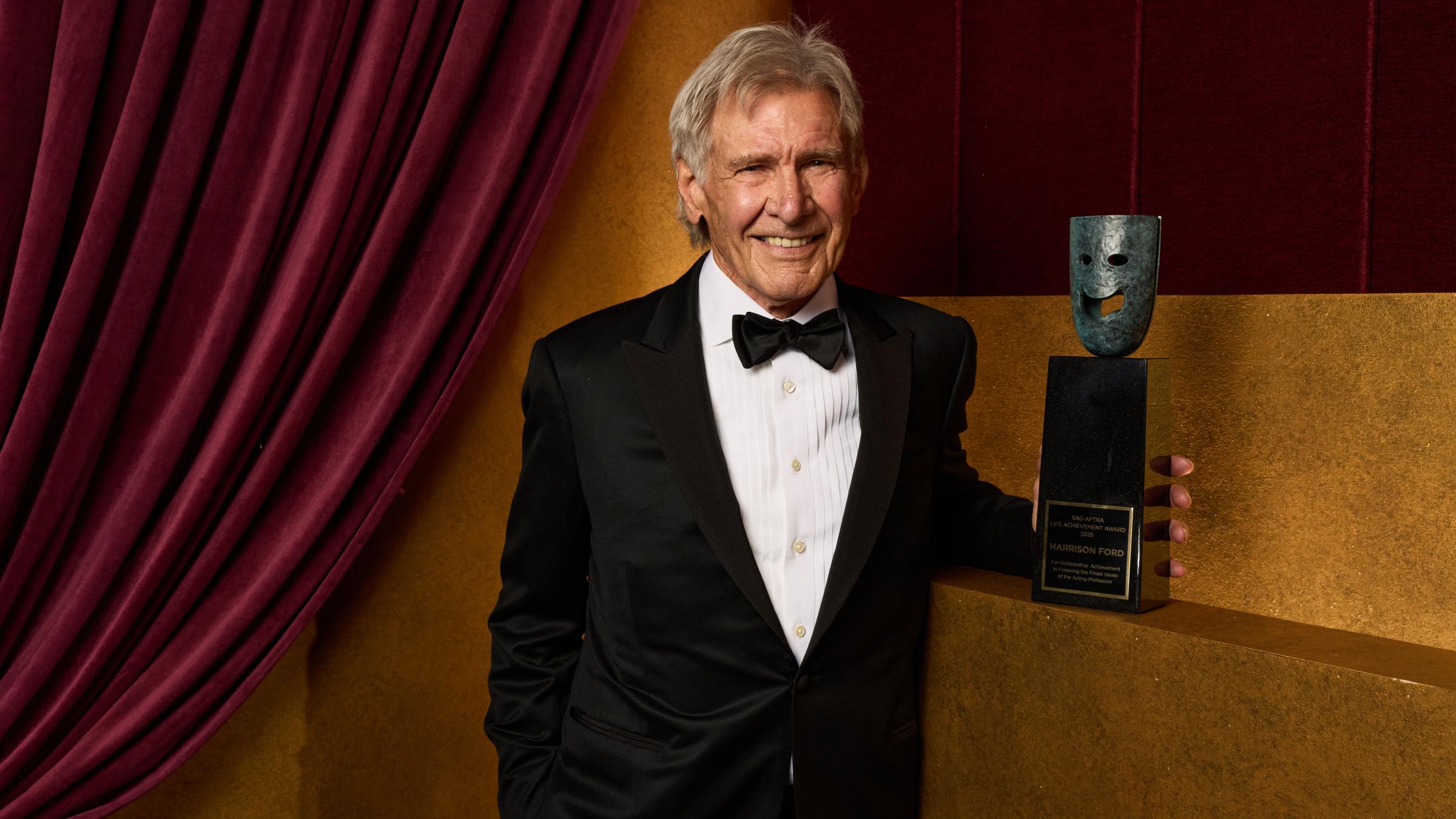 Harrison Ford posing with his Life Achievement statue at the 33rd Annual Actor Awards